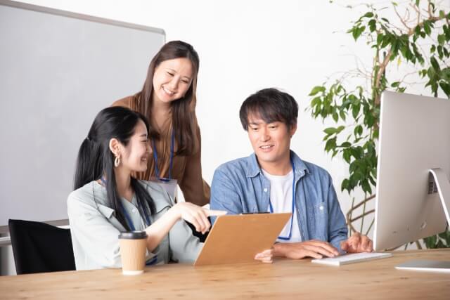 タブレットを見て笑う若いチーム